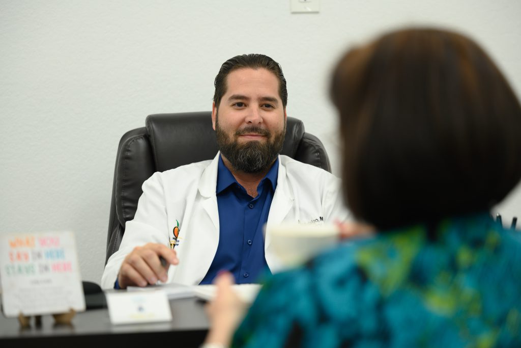 Dr. Alen Hidalgo talking with a patient about clinical research in Miami