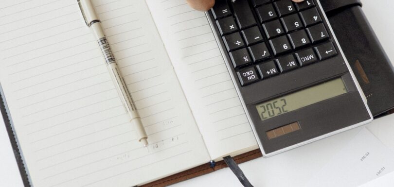 Person reviewing TMS therapy cost and insurance paperwork with a calculator in Miami